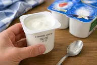 Yaourt nature ouvert avec date limite de consommation indiquée sur le pot