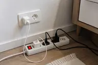 Multiprise avec plusieurs appareils électriques branchés dans une pièce de la maison