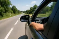 Voiture roulant avec la fenêtre ouverte sur une route en été